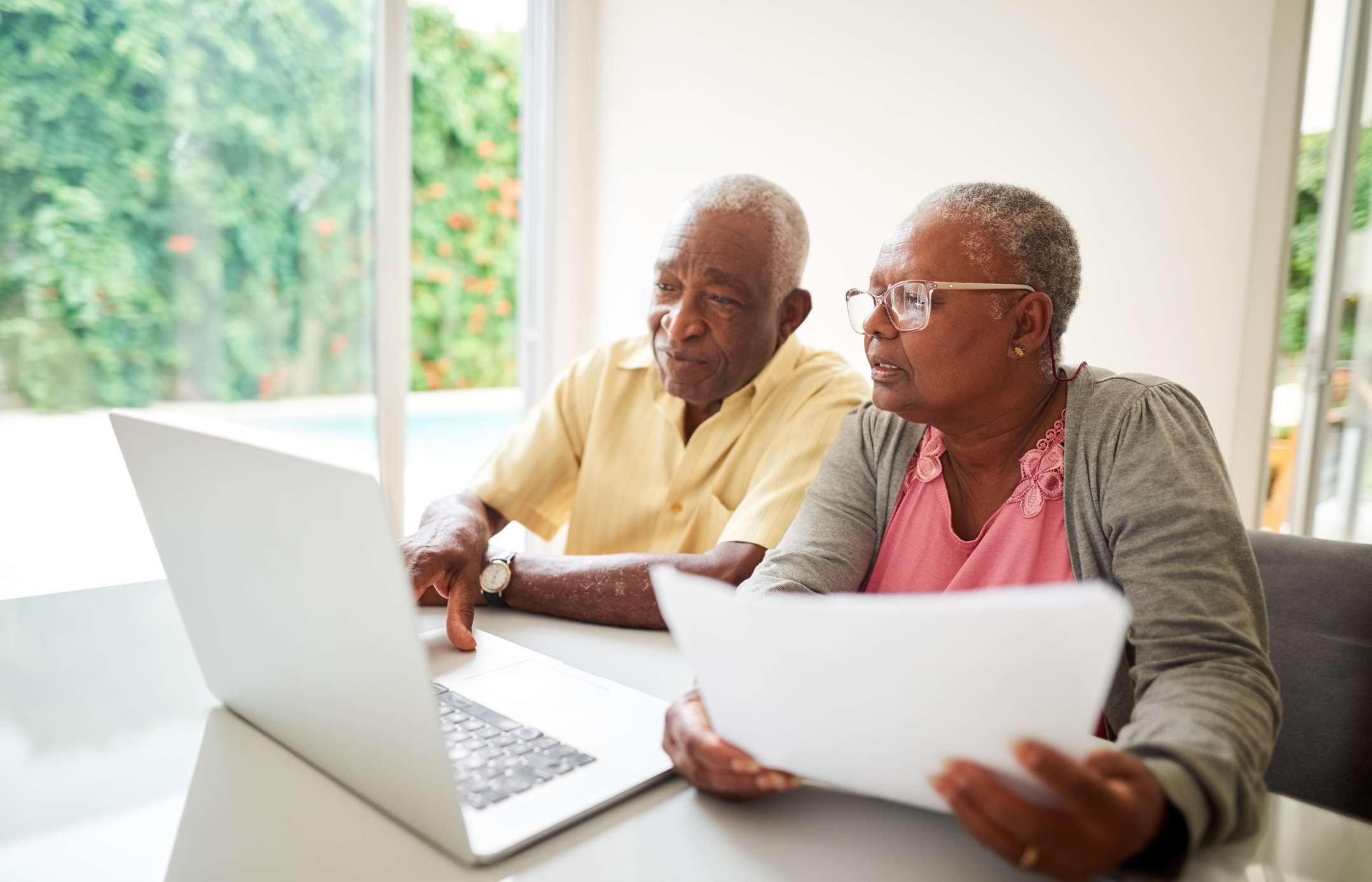 Older couple working together on laptop at home