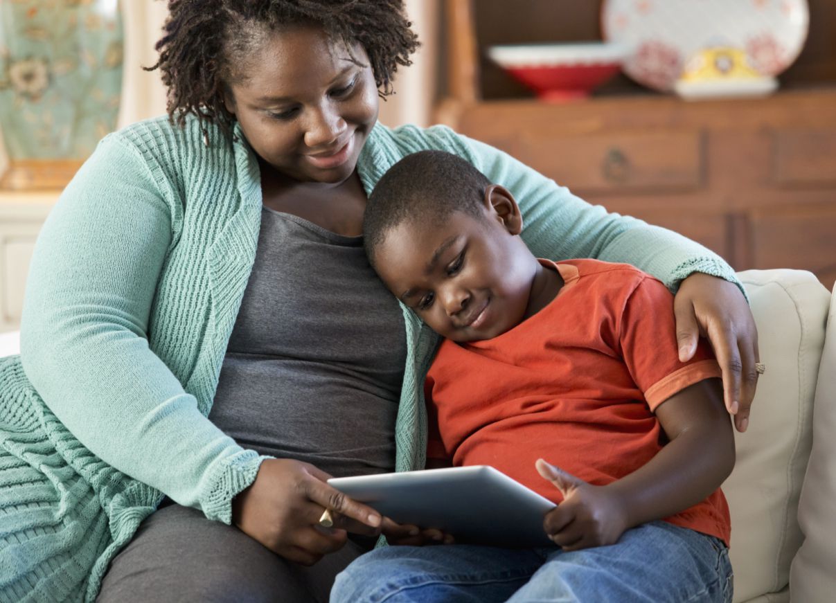 Woman and young boy reading a tablet together