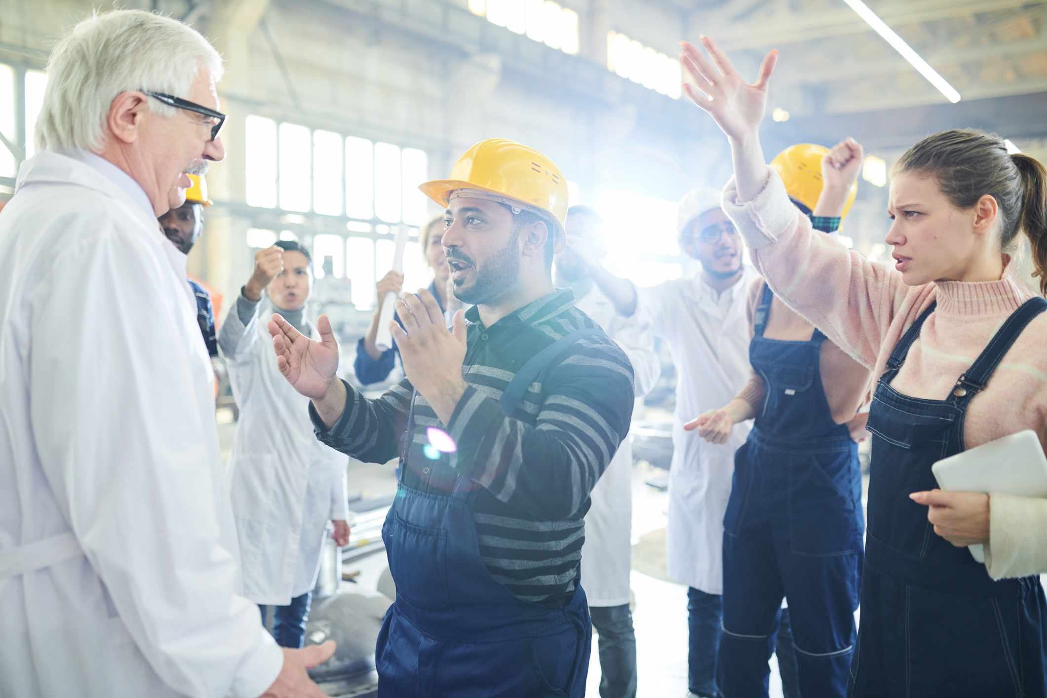 Workers in a factory arguing with a manager