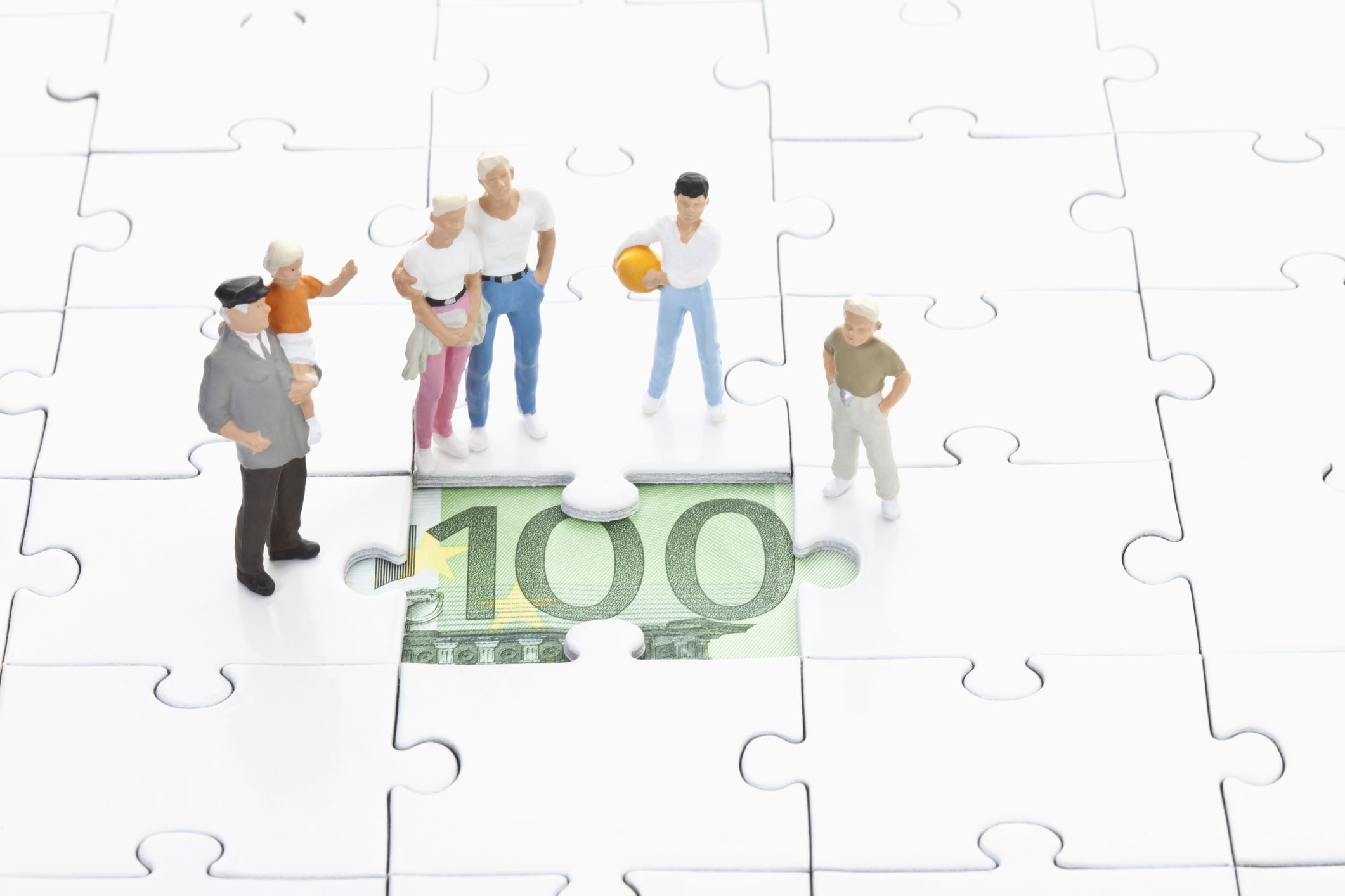A group of doll figures standing around a money puzzle piece indicating a Central Bank's monetary policy.