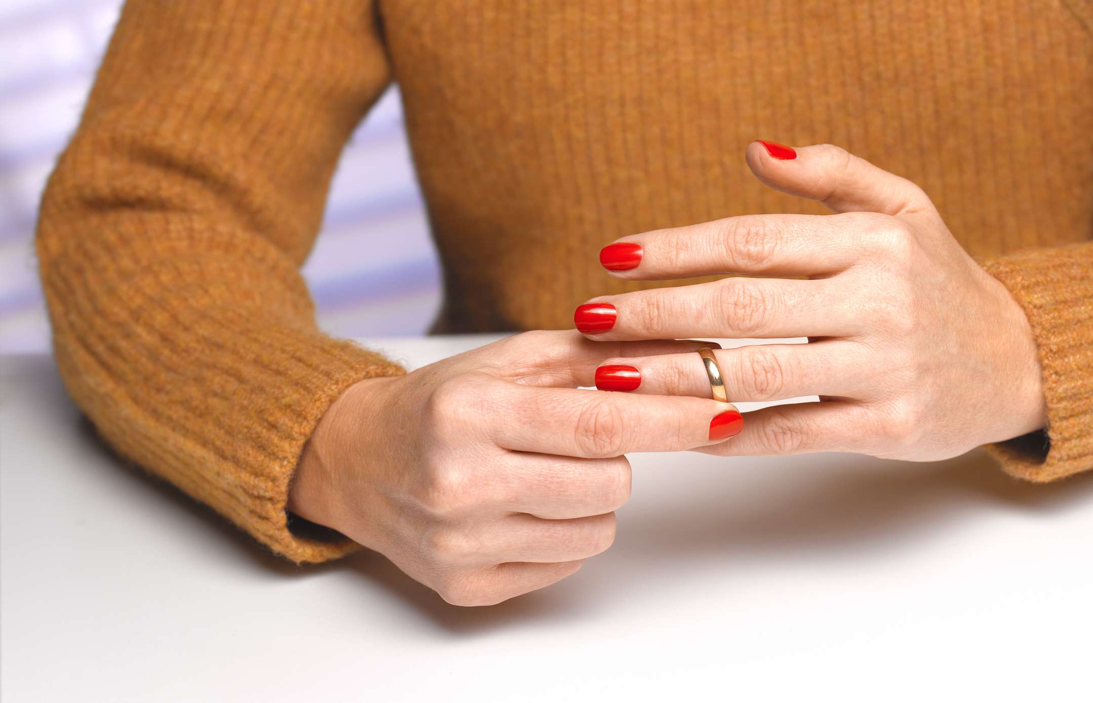 Divorced woman taking off wedding ring