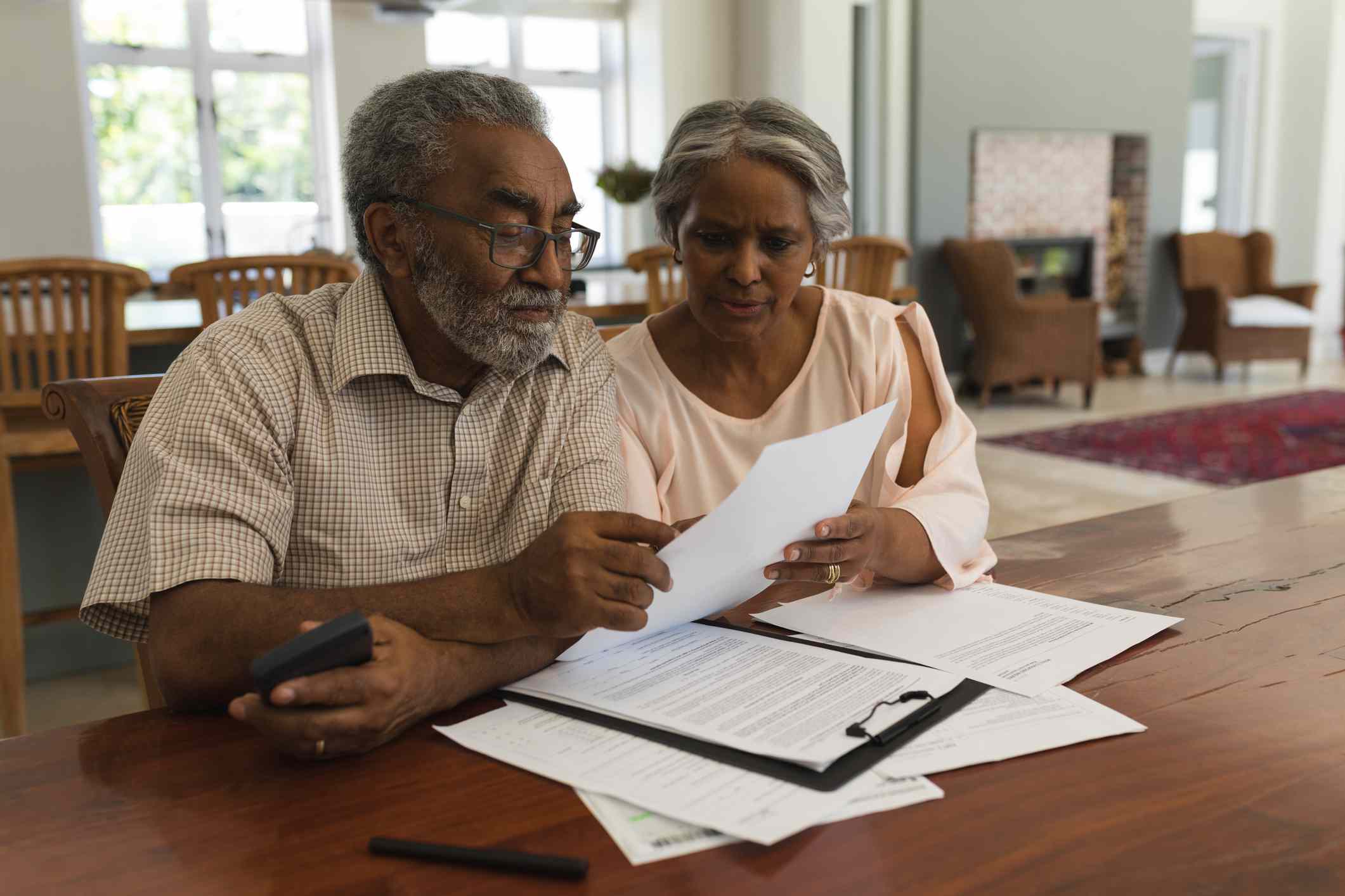 Senior couple discussing paperwork at home