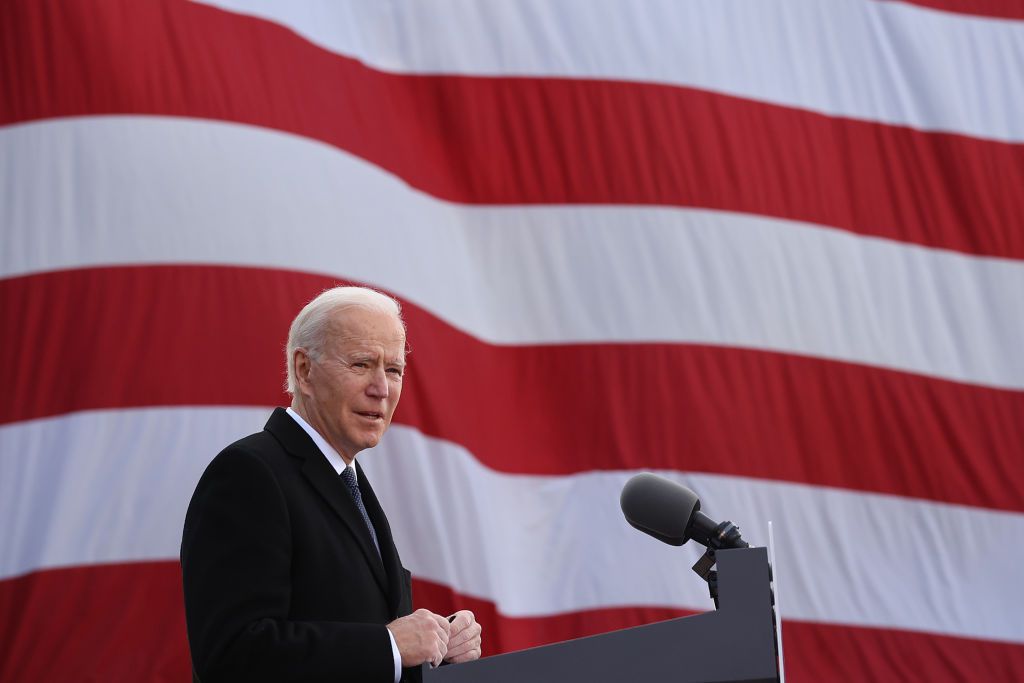 President Biden at microphone in front of an American flag