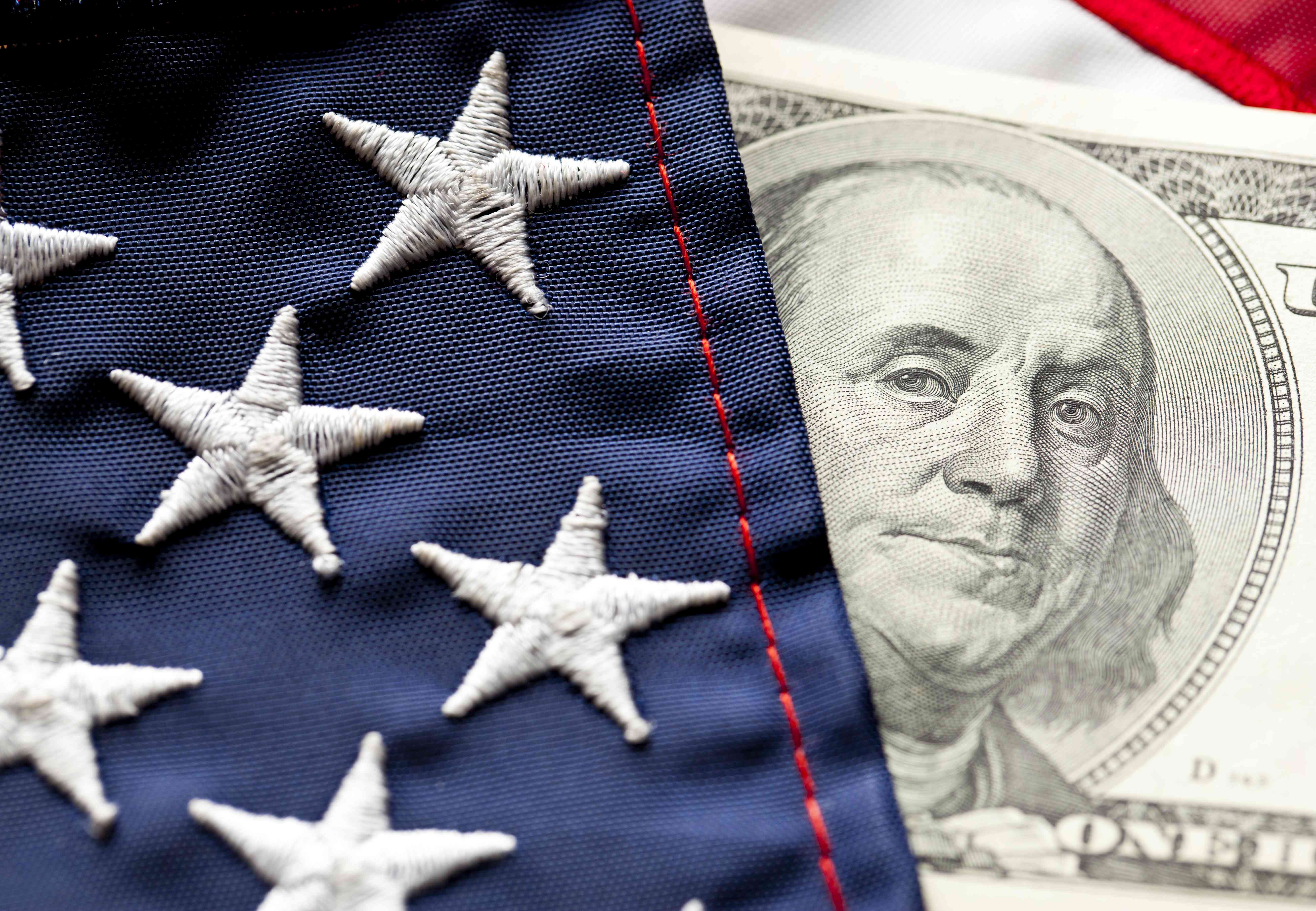 Close-up of U.S. flag and $100 U.S. bill