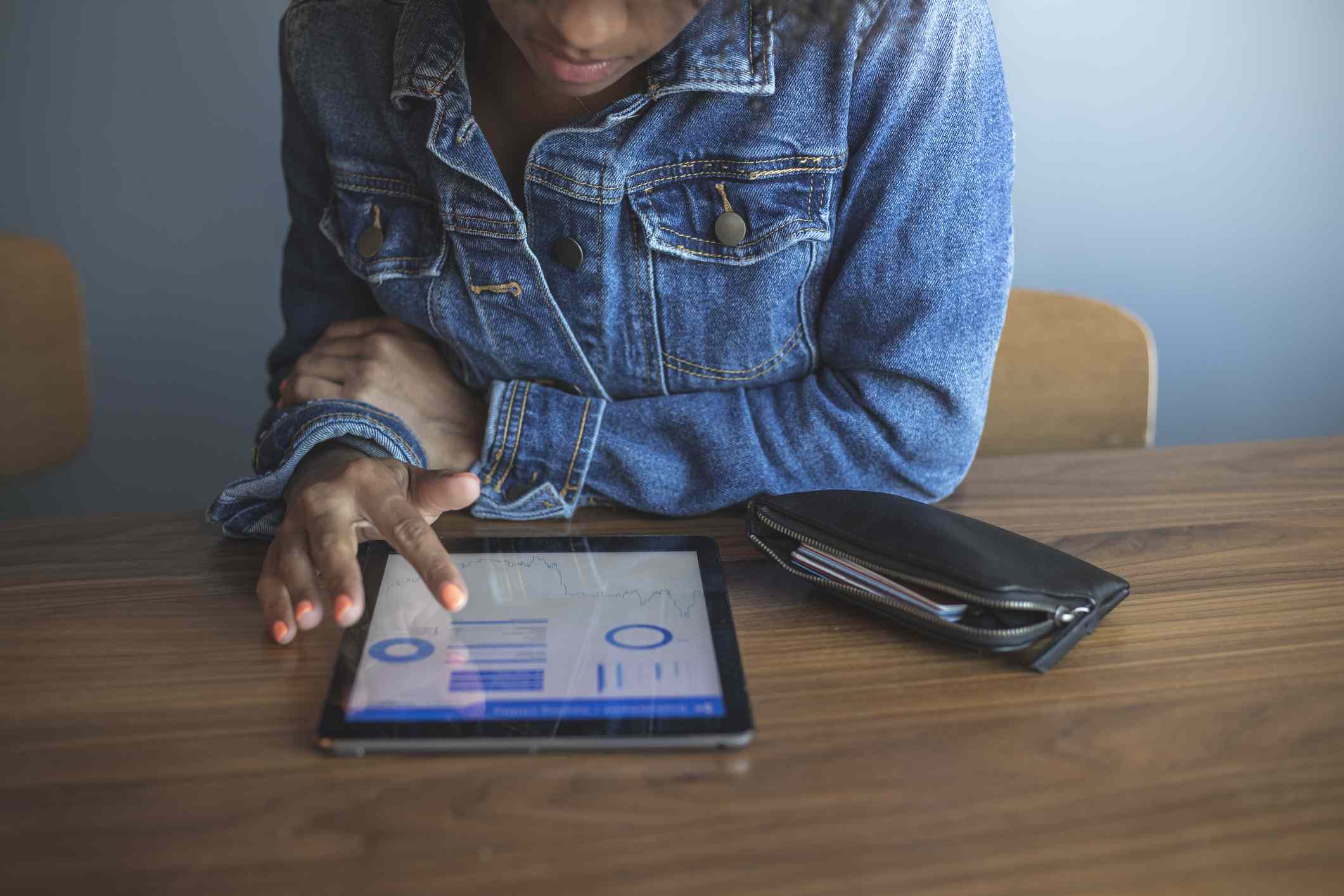 A young woman reviews her portfolio on a tablet