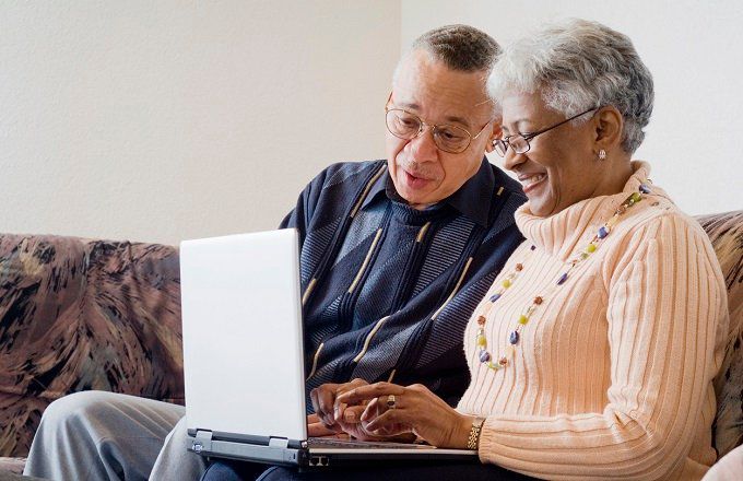 Older Black couple using a laptop