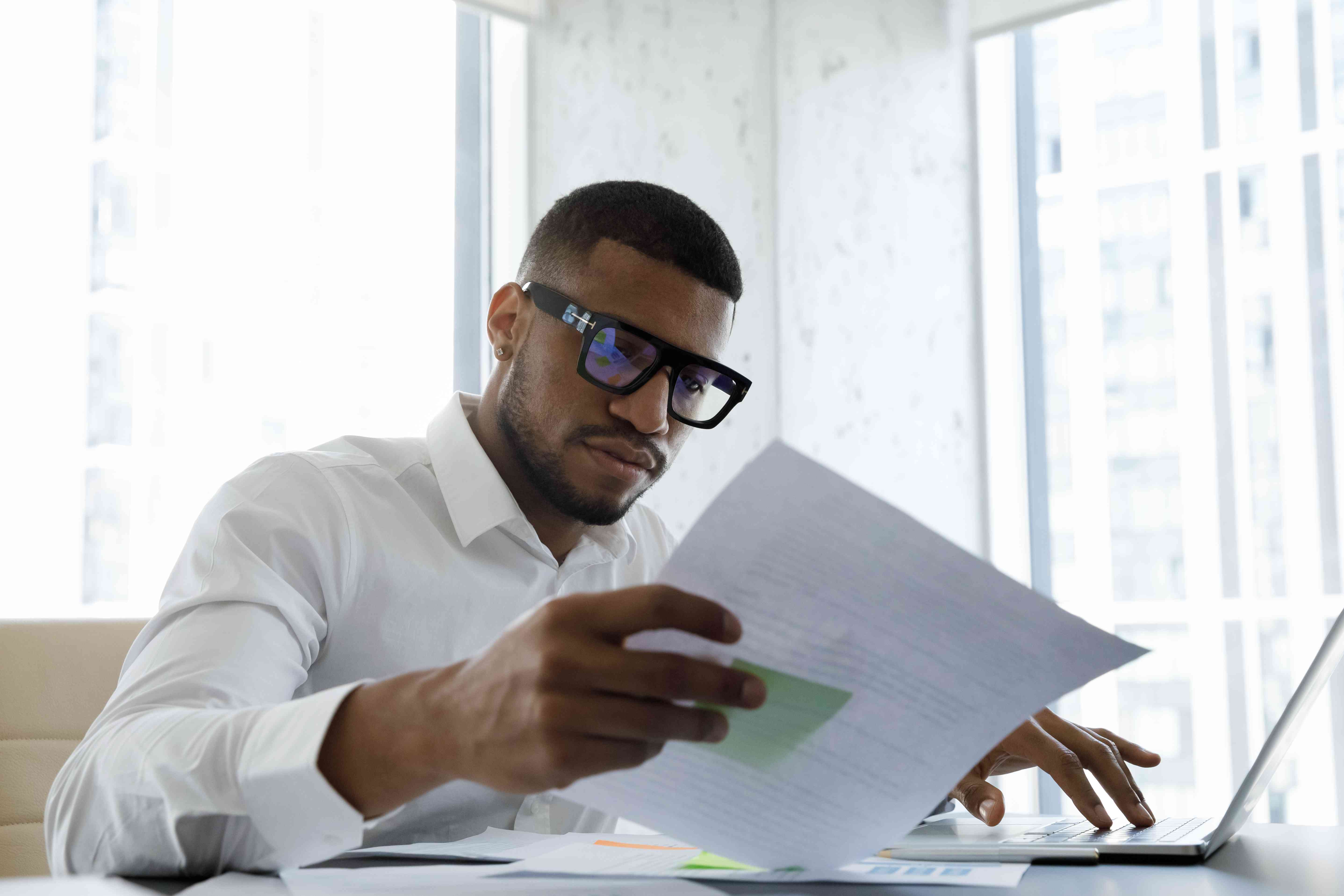 man with glasses reading paperwork