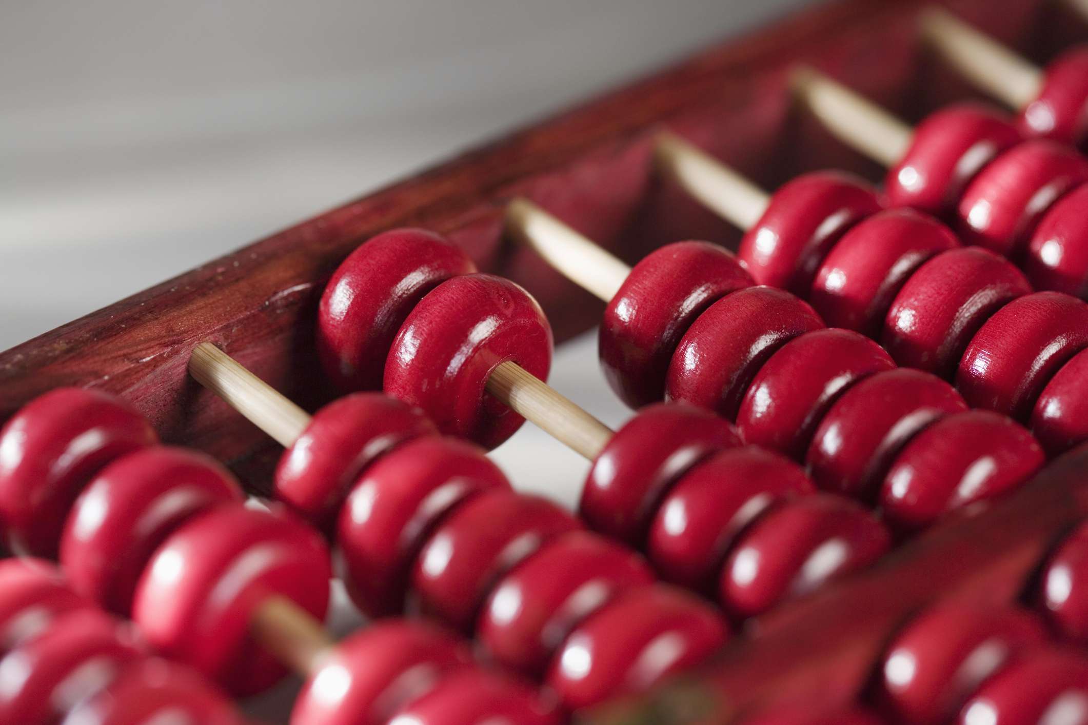 Closeup of red beads on a wooden abacus