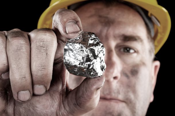 A silver miner holds a large nugget