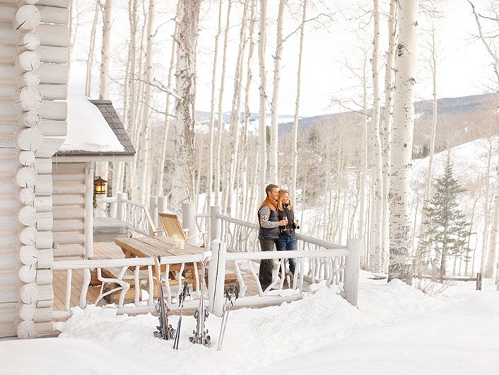 Couple standing outside a cabin in the snow